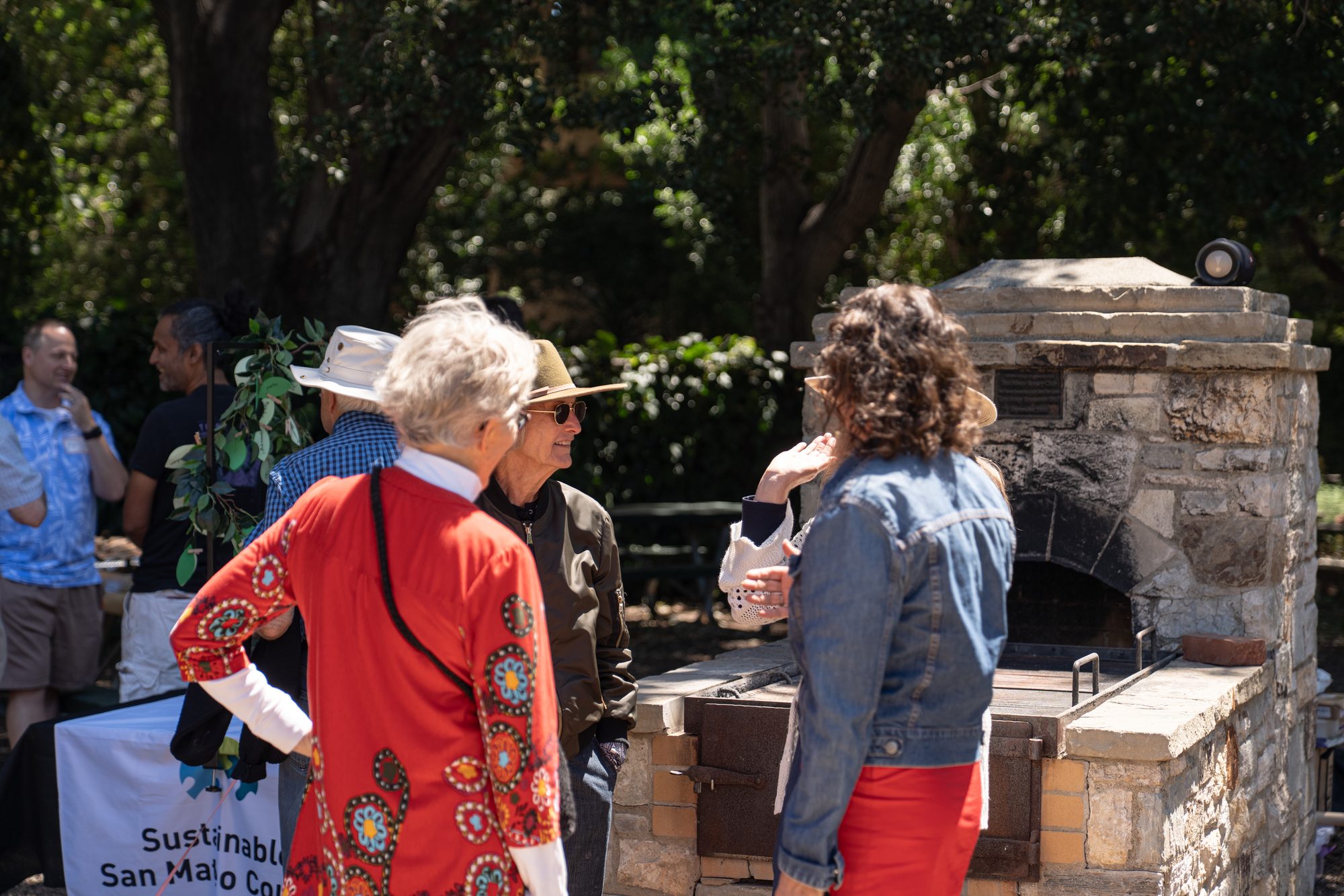 Attendees chatting by the outdoor oven