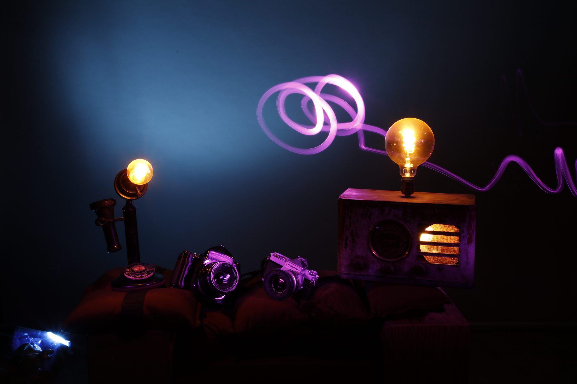 Vintage cameras and radio with purple light trail